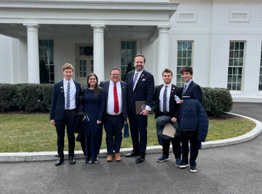 A photo of our seniors posing with Rabbi Pilichowski at the site of the AIPAC summit